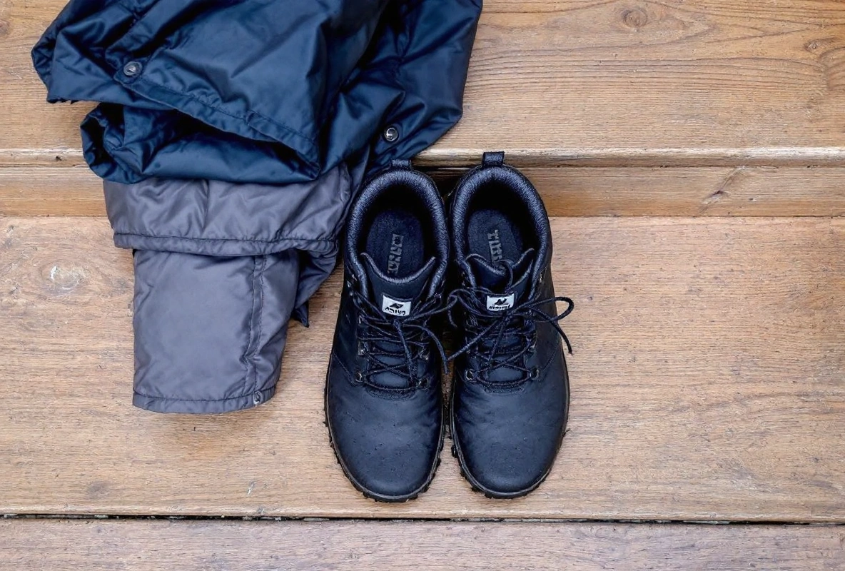 A pair of dark shoes placed toe to toe on cobblestones.